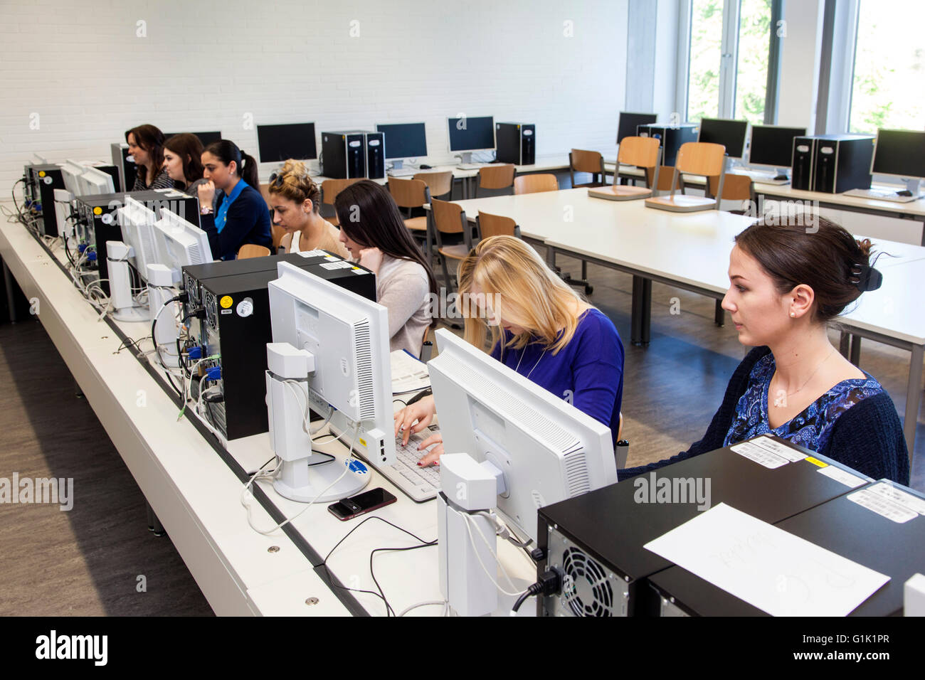 Studenti di sesso femminile in una scuola di formazione professionale durante la sua formazione presso la sala computer. Foto Stock