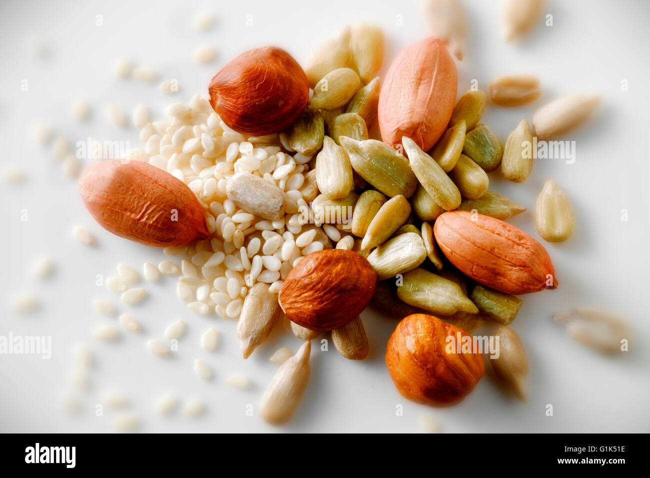 Ancora in vita del mix di arachidi, semi di girasole e semi di sesamo contro uno sfondo bianco, close up top shot Foto Stock