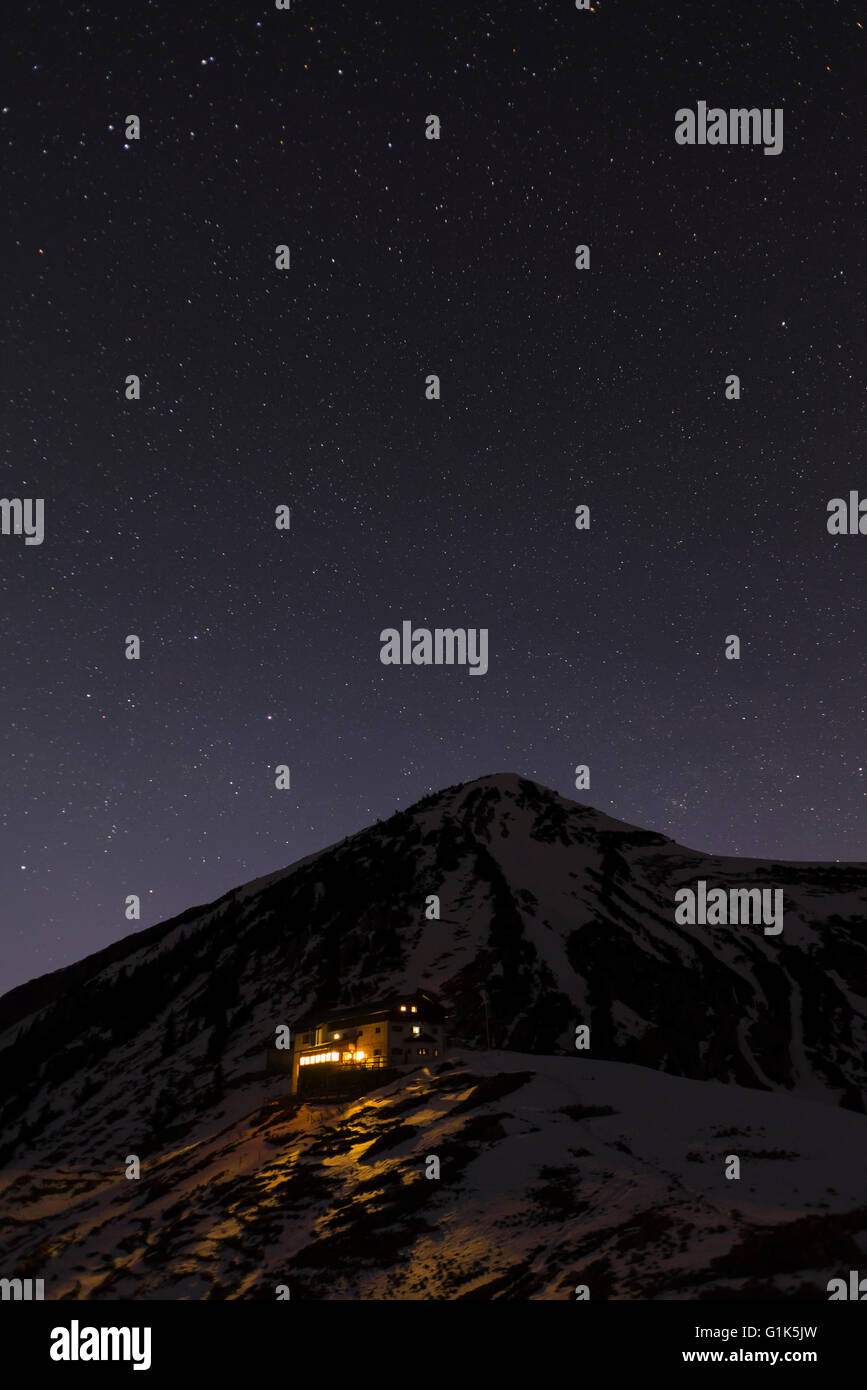 Cielo stellato e la luce che risplende dal Toelzer rifugio alpino di Karwendel mountain range, Tirolo, Austria Foto Stock