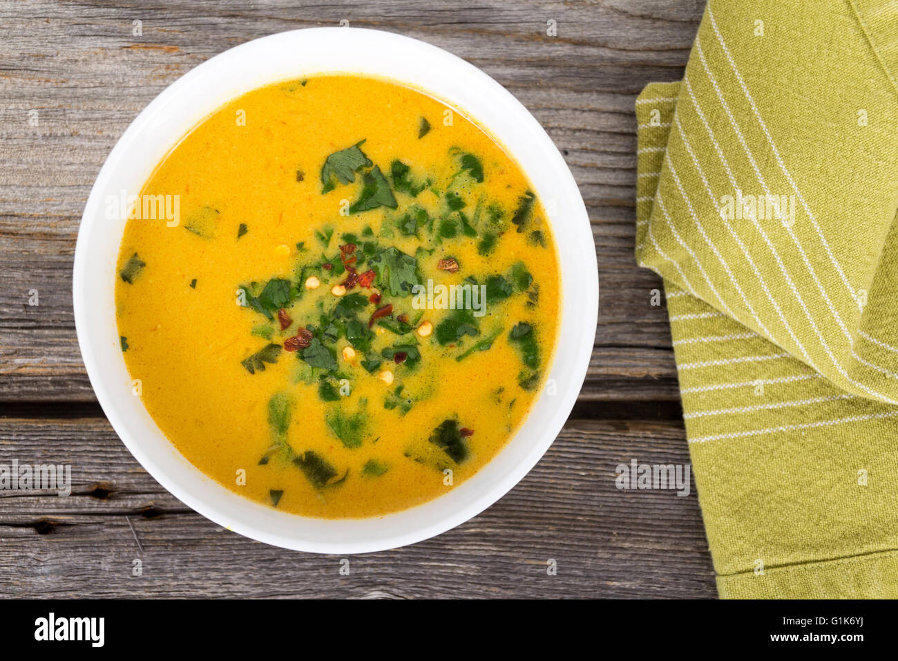 Thai yellow curry zuppa con il coriandolo sul tavolo rustico Foto Stock