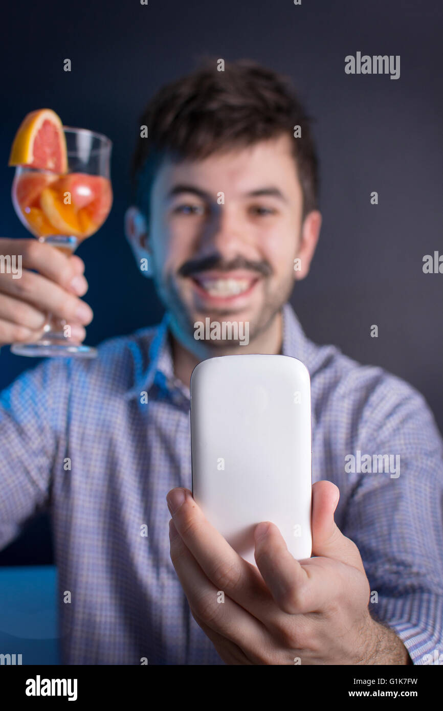 Uomo pazzo facendo una selfie con un cocktail presso il partito Foto Stock