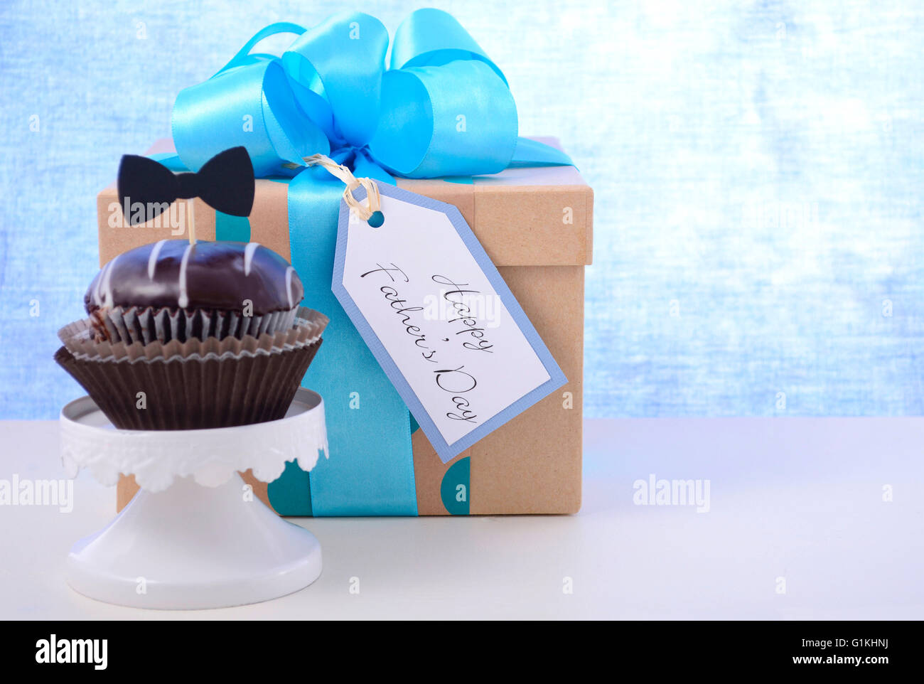 Felice giorno padri cupcake dono in blu pallido e bianco sullo sfondo di legno. Foto Stock