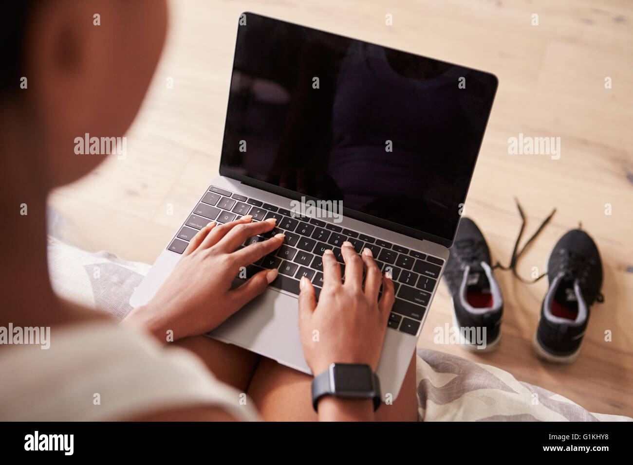 Giovane donna nera utilizzando il computer portatile, oltre a vista con spallamento Foto Stock