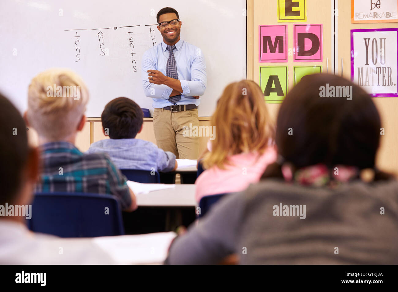 Insegnante di fronte ad una scuola elementare di classe Foto Stock
