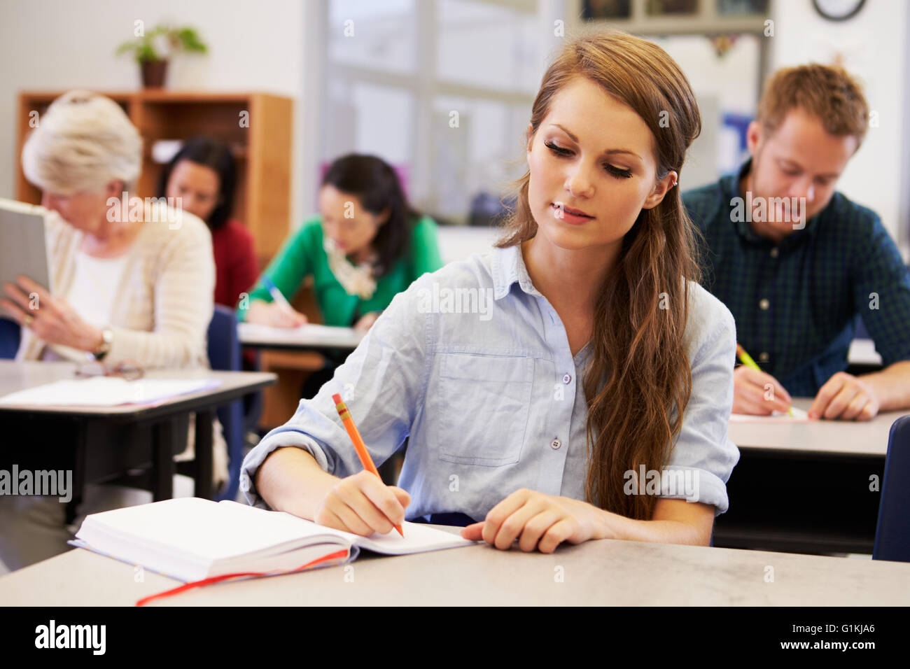 Giovane donna a studiare in un'istruzione per adulti della classe Foto Stock