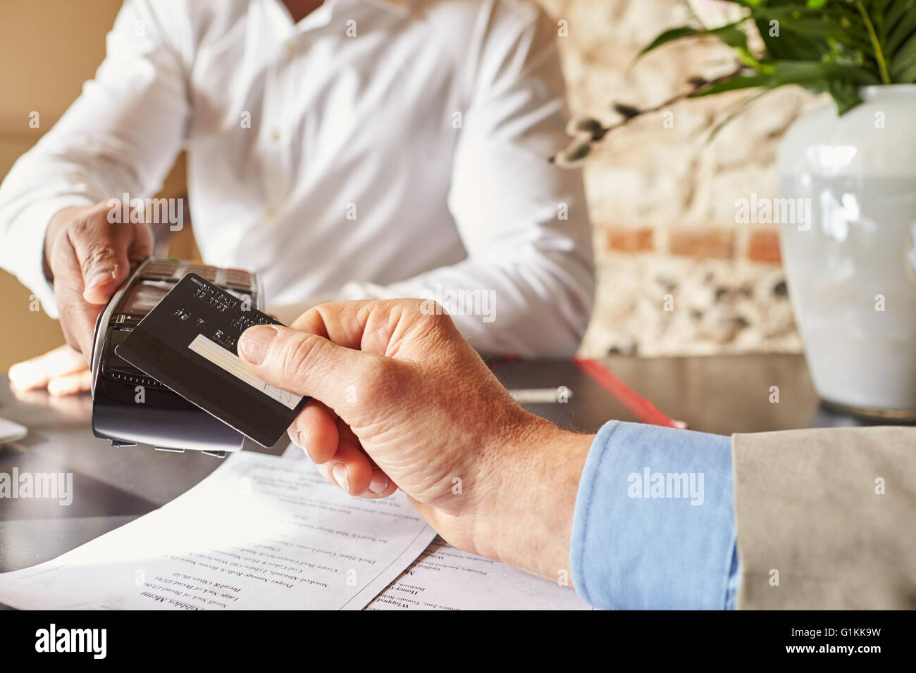 Valutazione rendendo carta contactless il pagamento in hotel, mani dettaglio Foto Stock