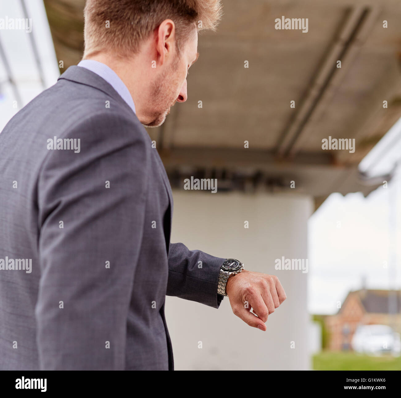 Uomo che guarda il suo orologio correndo per il lavoro Foto Stock