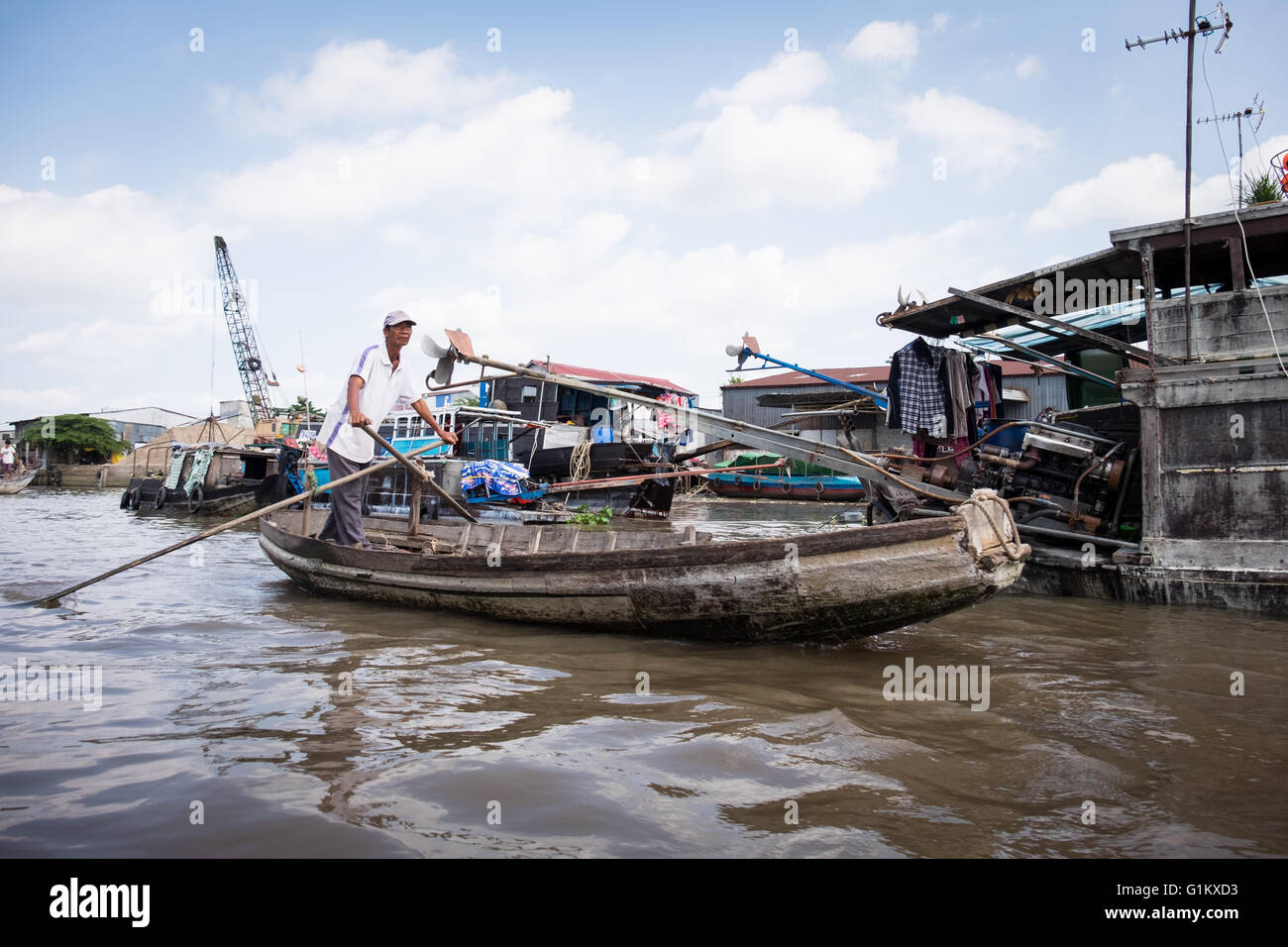 Un uomo paddling attraverso Can Tho mercato galleggiante in Vietnam Foto Stock