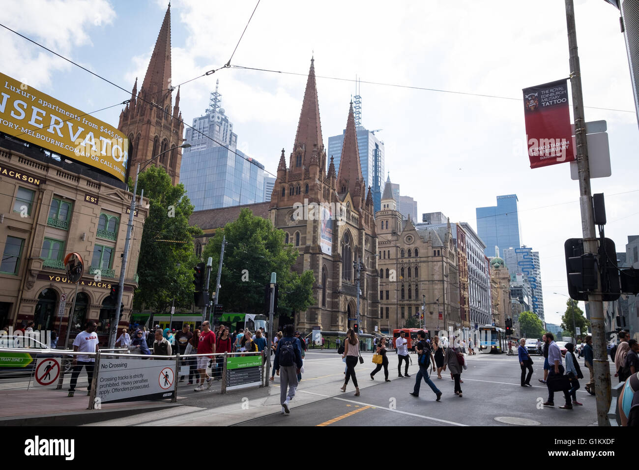 Le persone che attraversano la Flinders Street vicino alla Cattedrale di San Paolo a Melbourne, Australia Foto Stock