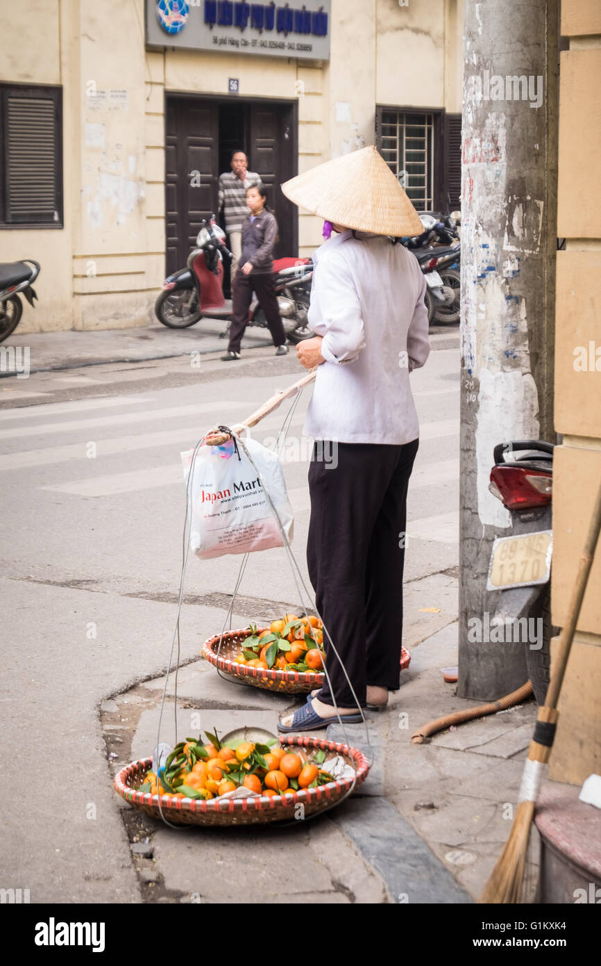 Una signora di vendita Arance Mandarini nella città vecchia di Hanoi e Foto Stock