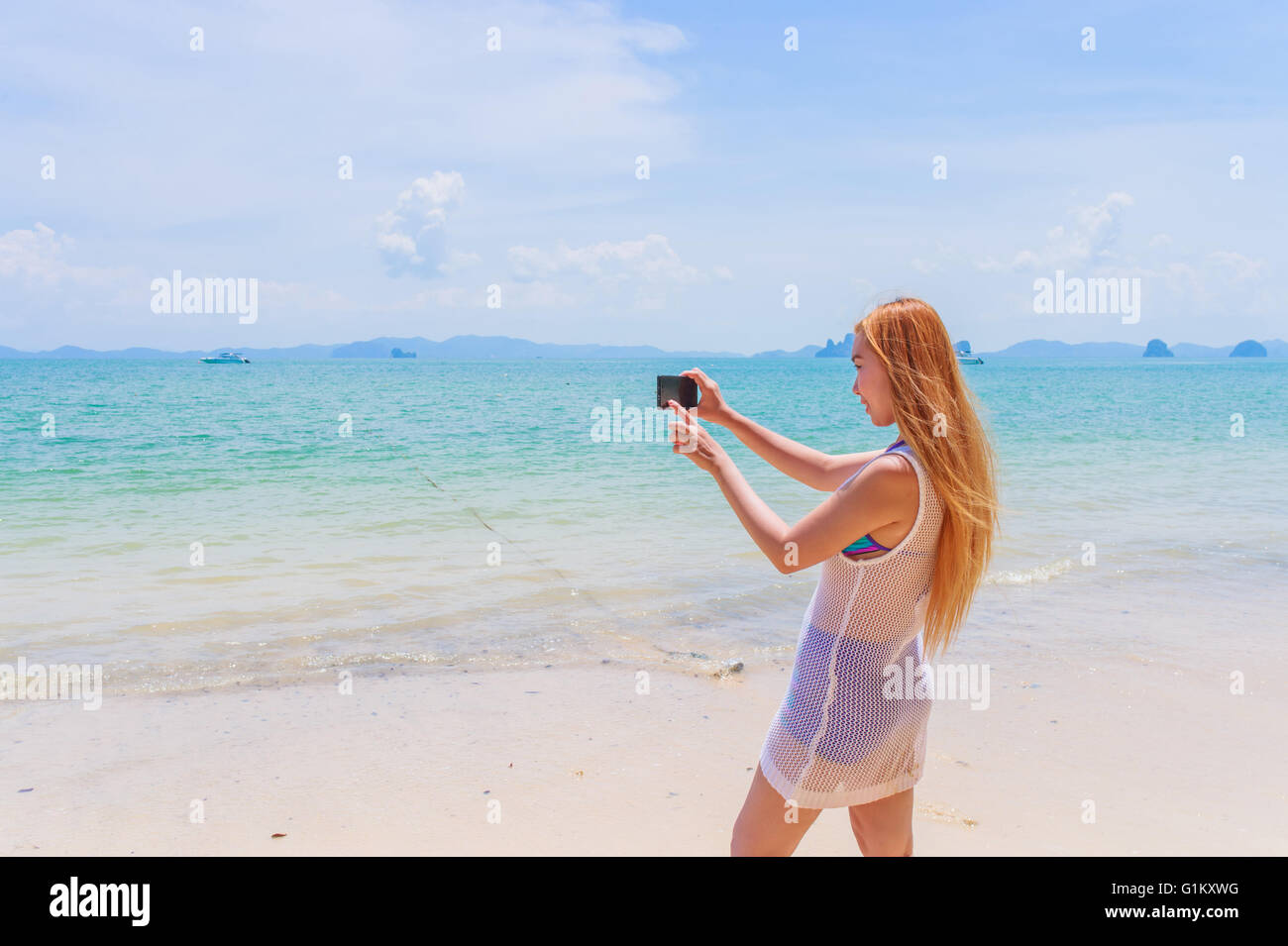 Felice attraente bionda in bikini prendendo un auto immagine su una bellissima spiaggia Sunny Beach Foto Stock