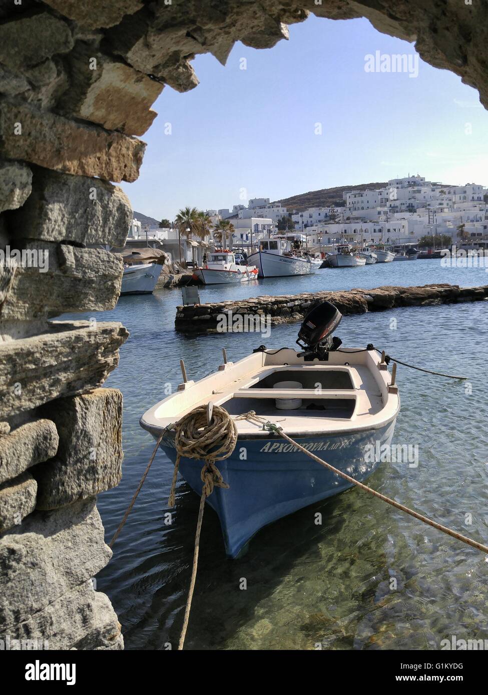 Una piccola barca da pesca presso i ruderi del castello a Naoussa Bay sull'isola di Paros Grecia. Foto Stock