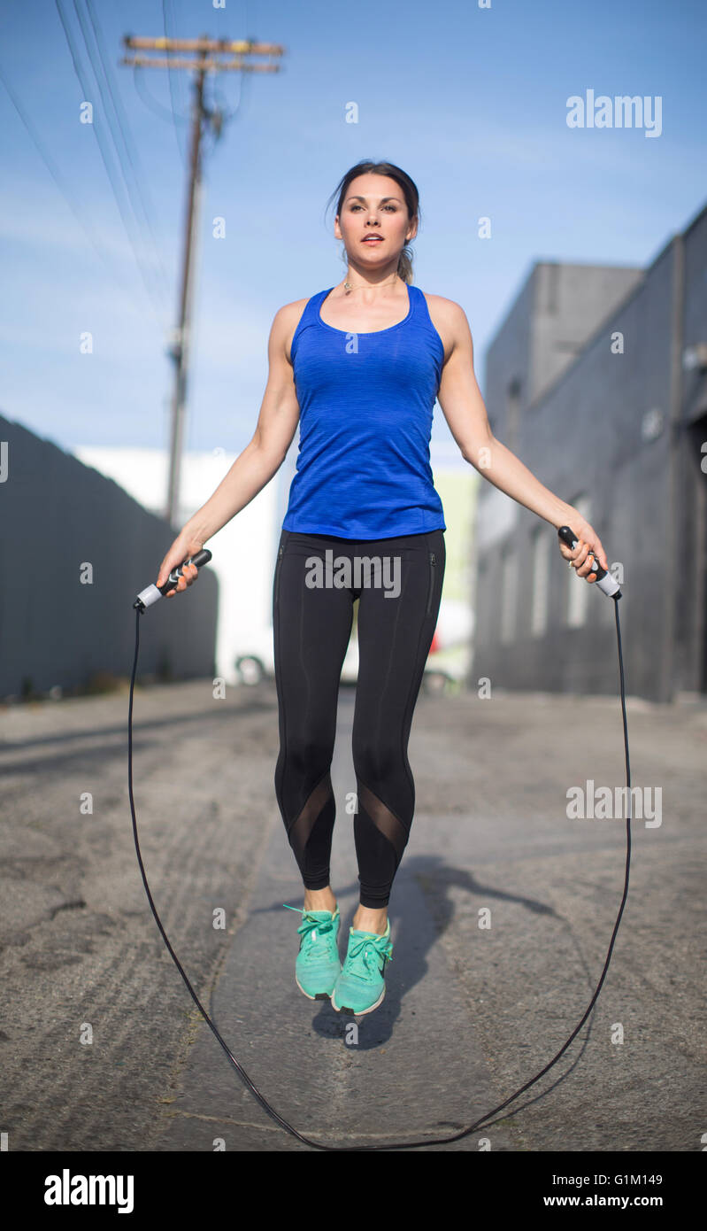 Urban fitness donna un salto con la corda in una Los Angeles vicoletto. Foto Stock