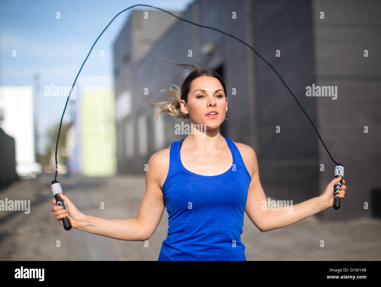 Urban fitness donna un salto con la corda in una Los Angeles vicoletto. Foto Stock