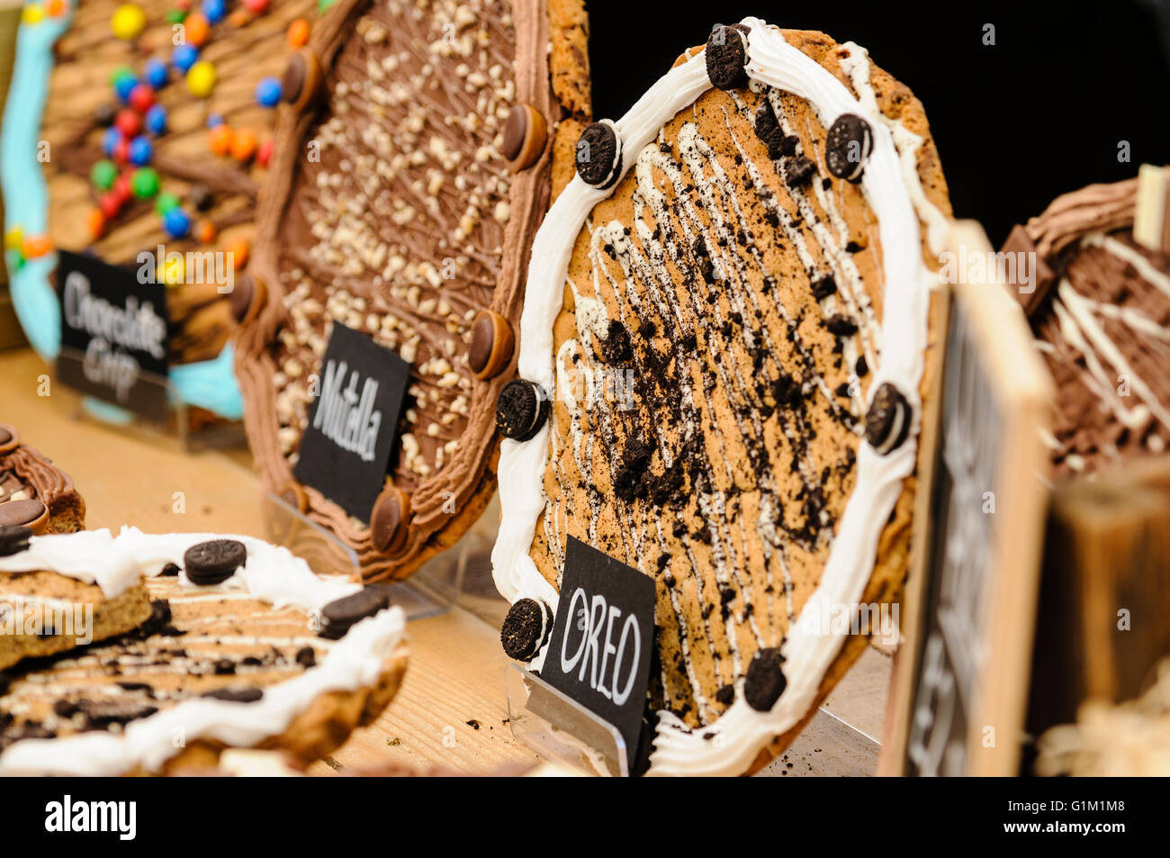 Chocolate Chip, Nutella e Oreo cookie "pizze" in vendita su un mercato in stallo. Foto Stock