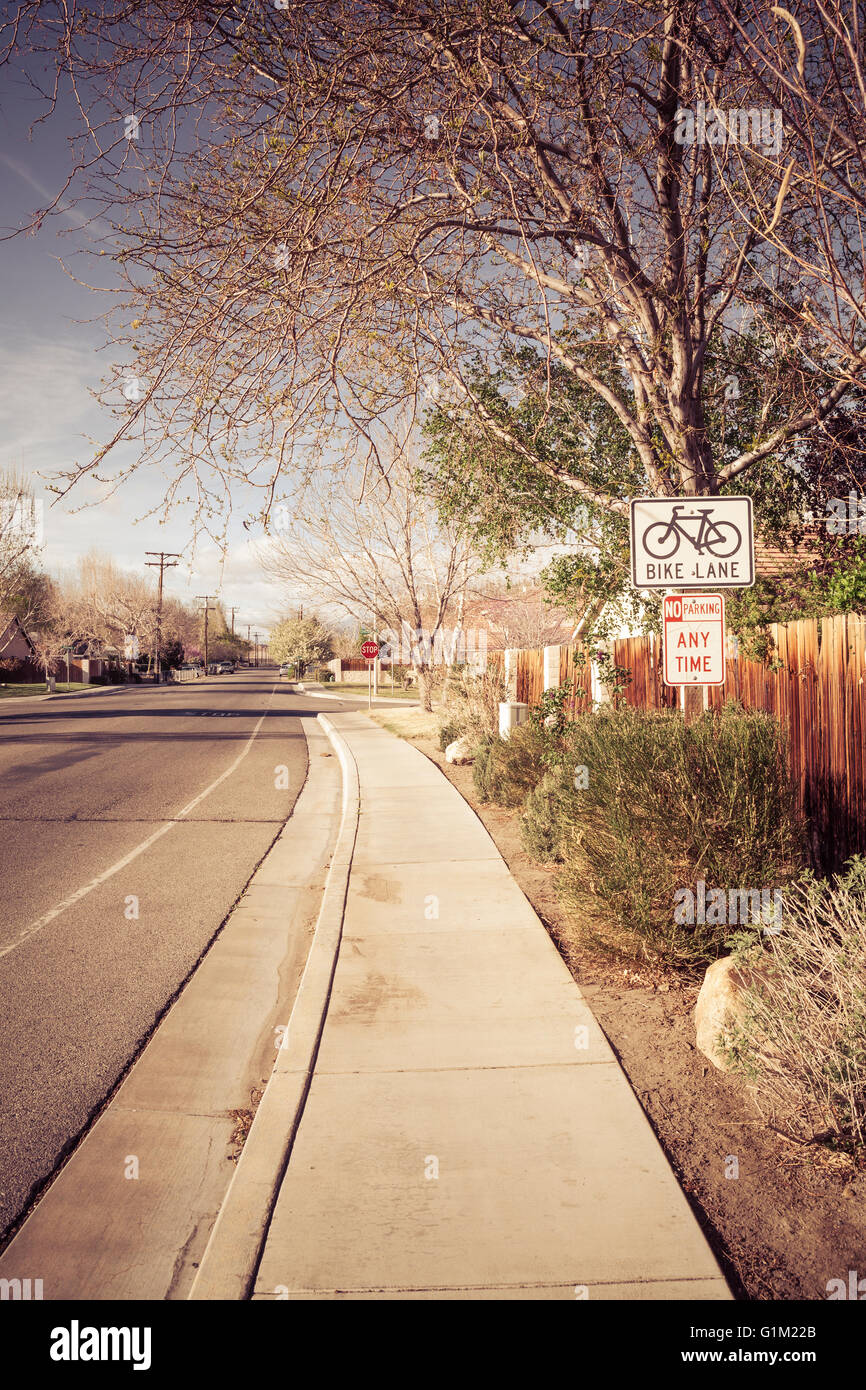 Pista ciclabile firmare in un tipico U.S. classe media suddivisione di quartiere con un marciapiede. Foto Stock