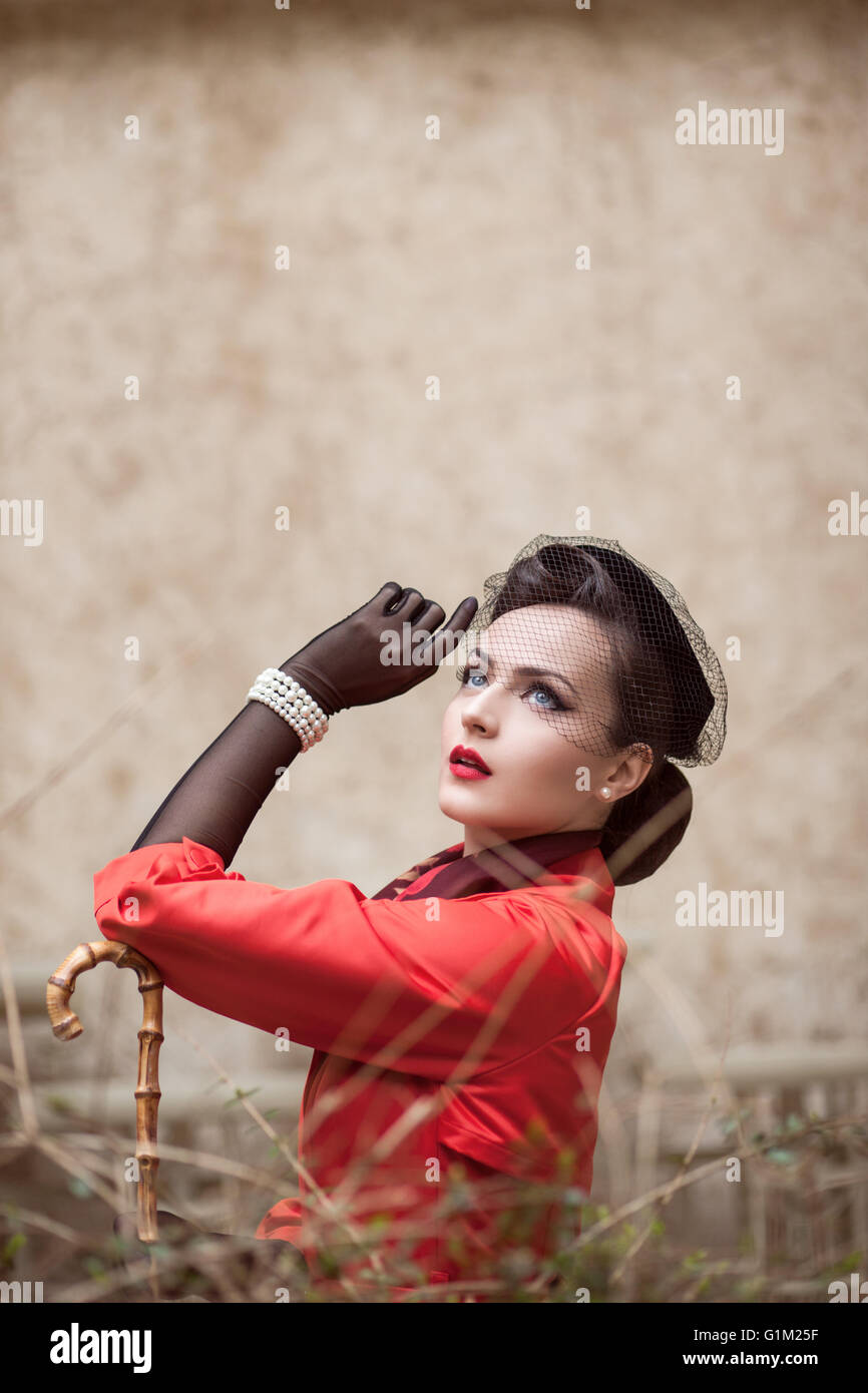 Ritratto di una bella donna retrò in cappotto rosso Foto Stock