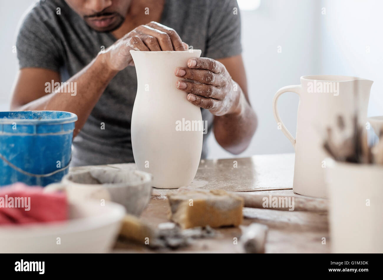 Artista nero sagomatura vaso in ceramica in studio Foto Stock
