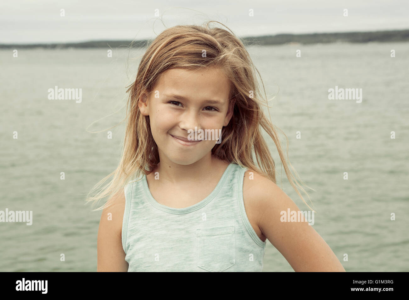 Caucasian ragazza sorridente vicino al lago Foto Stock