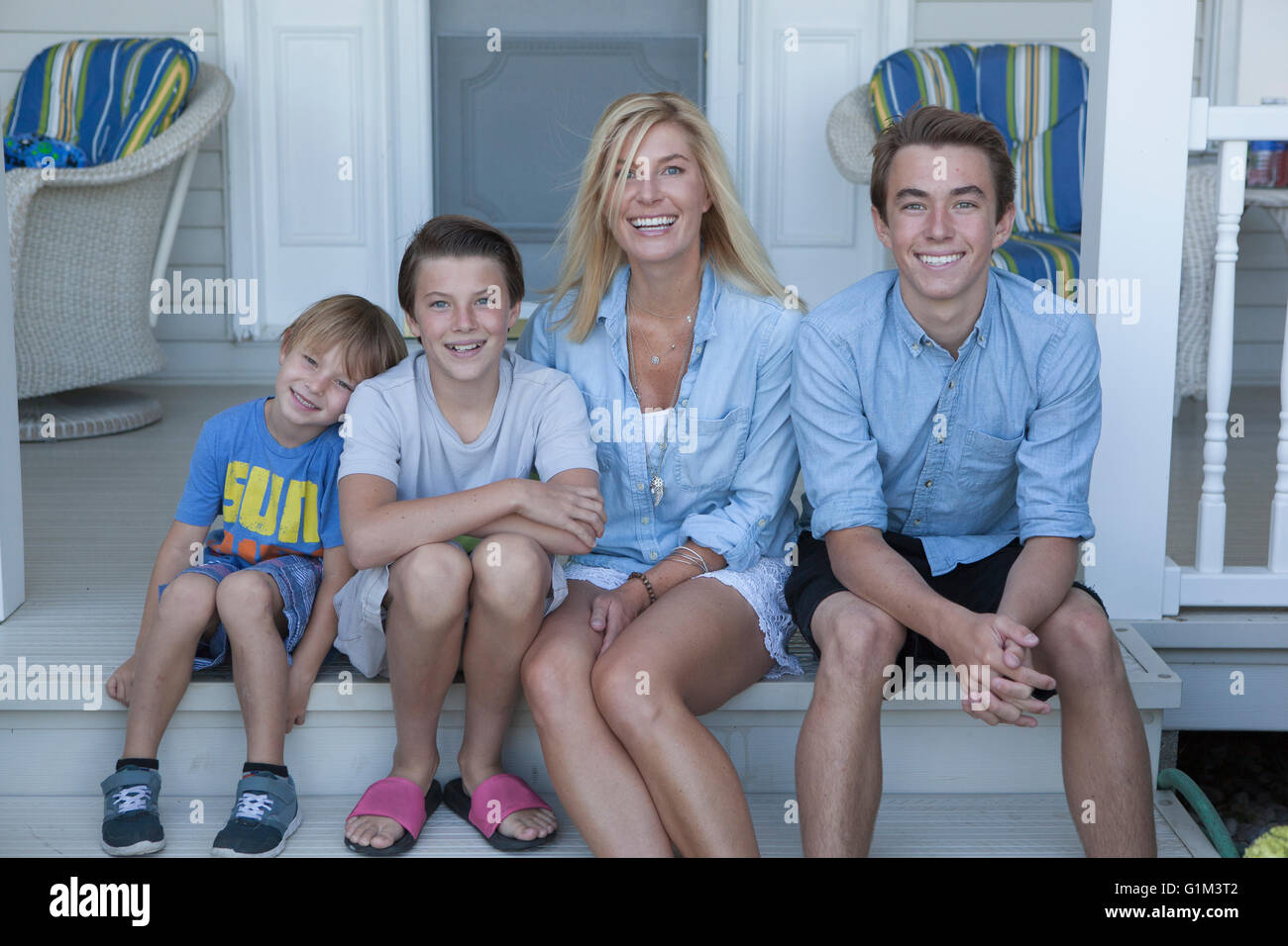 Caucasian madre e figli sorridente sul portico Foto Stock