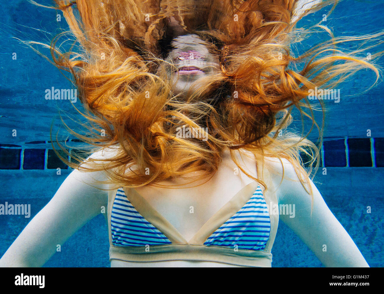 La donna caucasica sott'acqua in piscina Foto Stock