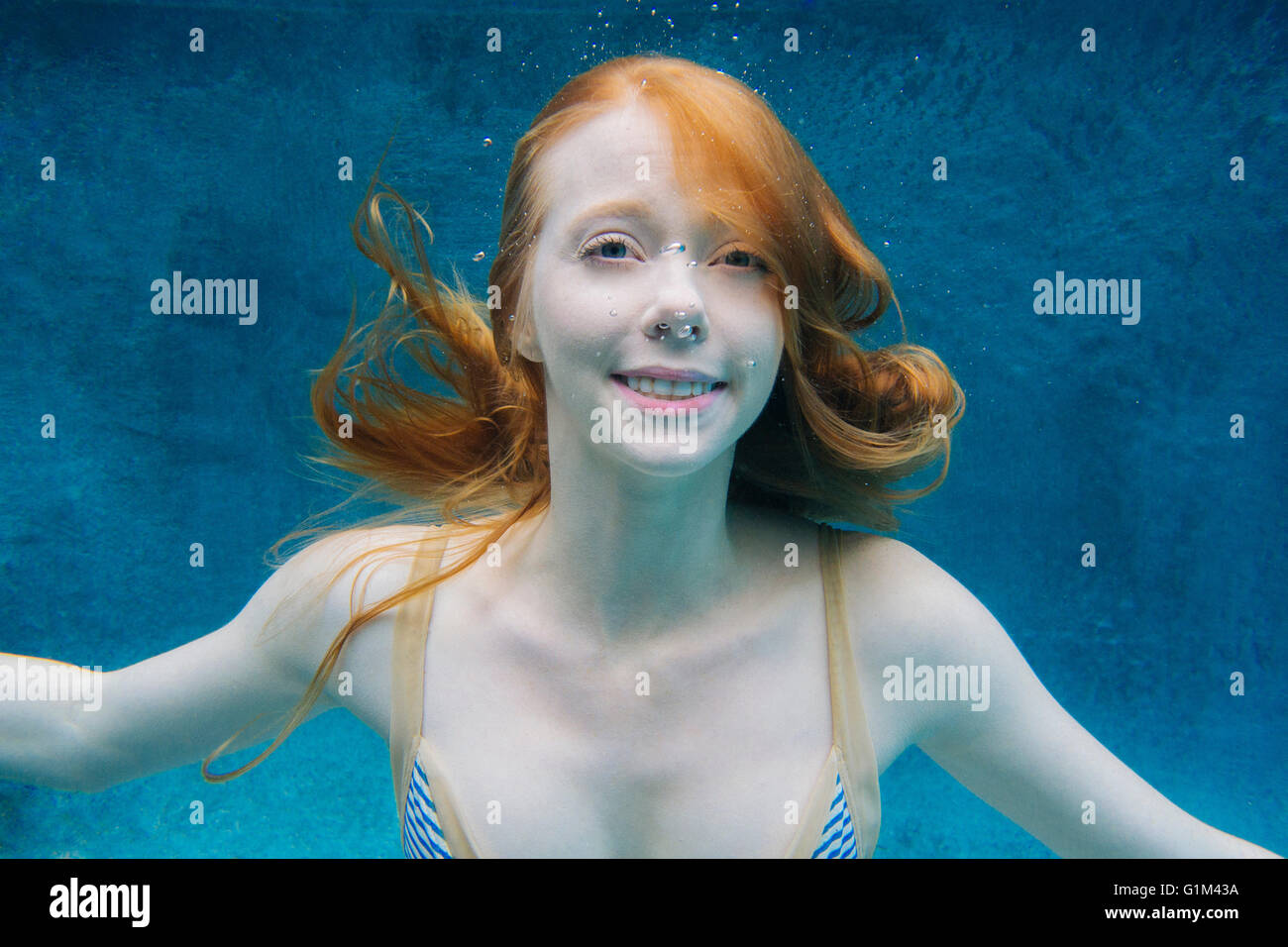Caucasian donna sorridente sott'acqua in piscina Foto Stock