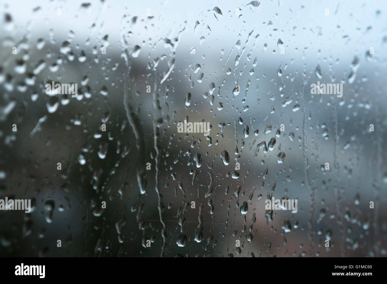 Una chiusura di gocce di pioggia gocciolare una finestra su un wet Rainy day Foto Stock