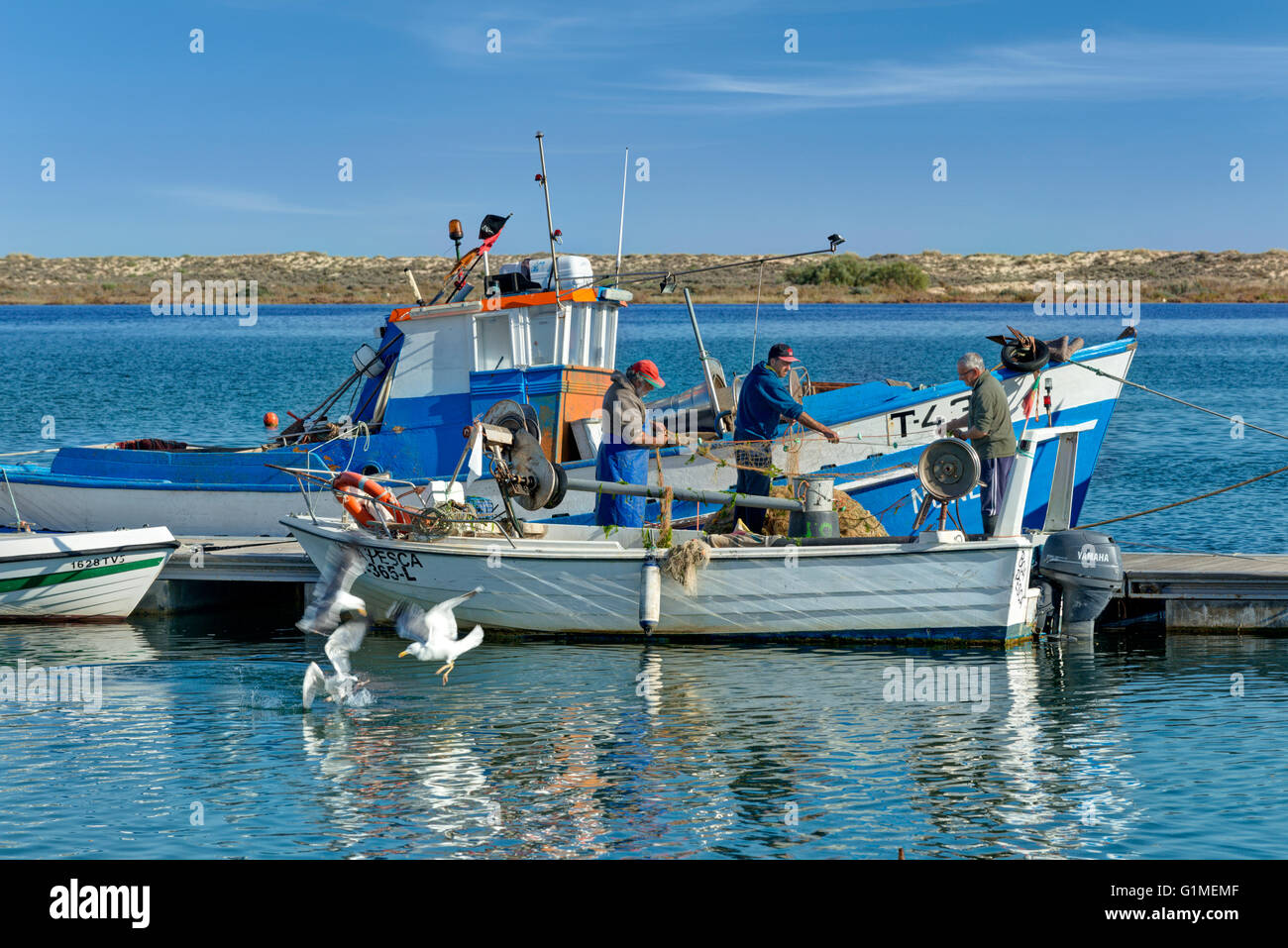 I pescatori portoghesi riassettavano le reti a Cabanas in Algarve orientale Foto Stock