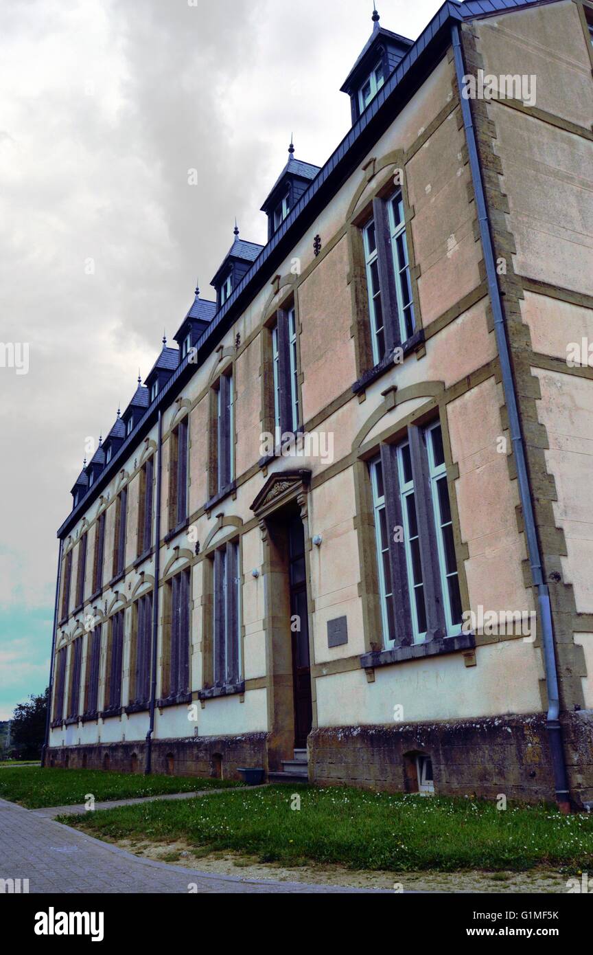 Edificio residenziale rende di pietre marroni precedentemente occupato da una scuola. Foto Stock