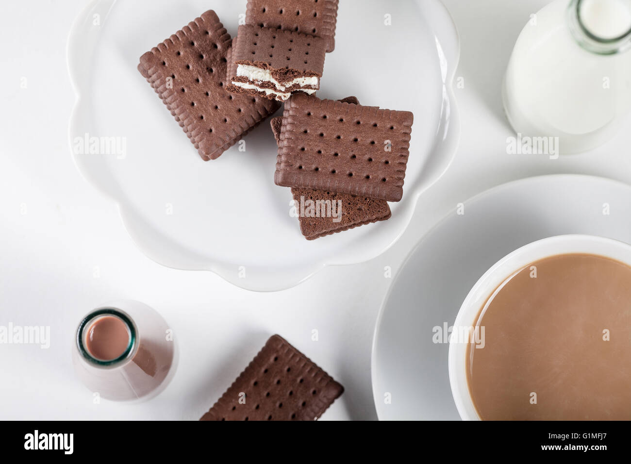 Tazza di caffè e poche bottiglie di latte e cioccolato frappè su sfondo bianco dalla parte superiore Foto Stock