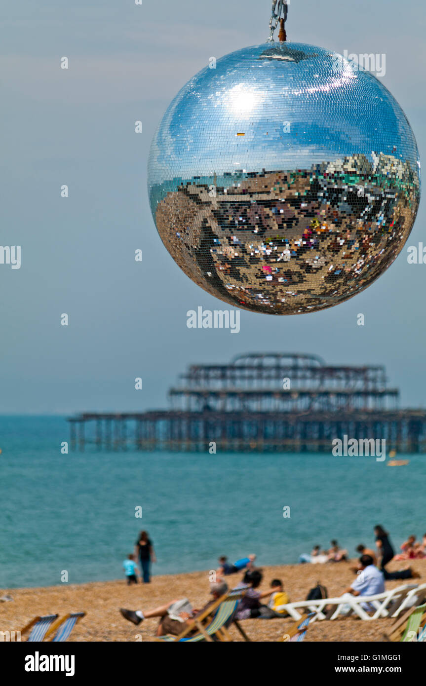 La spiaggia di Brighton è riflesso in una sfera dello specchio appeso in una delle caffetterie sul lungomare. I resti del molo Ovest può essere visto dietro. Foto Stock
