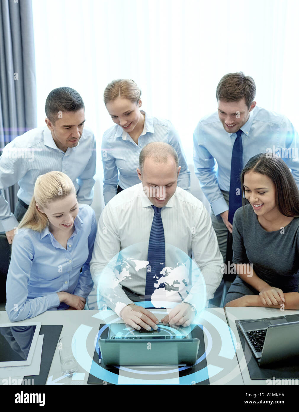 Sorridente la gente di affari con computer portatile in ufficio Foto Stock