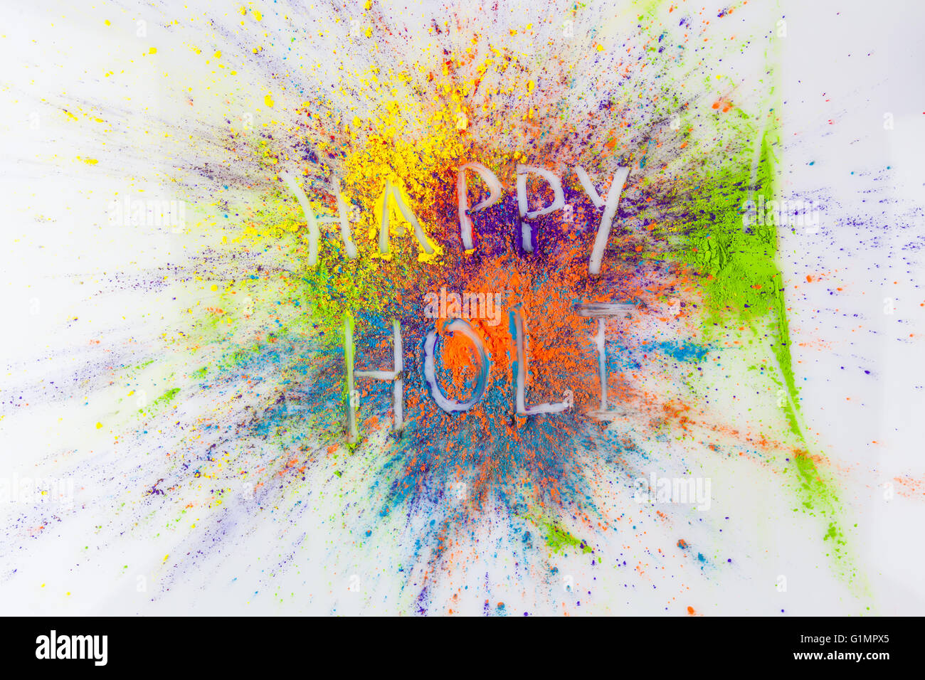 Happy Holi scritto sulla vibrante Holi polvere Foto Stock