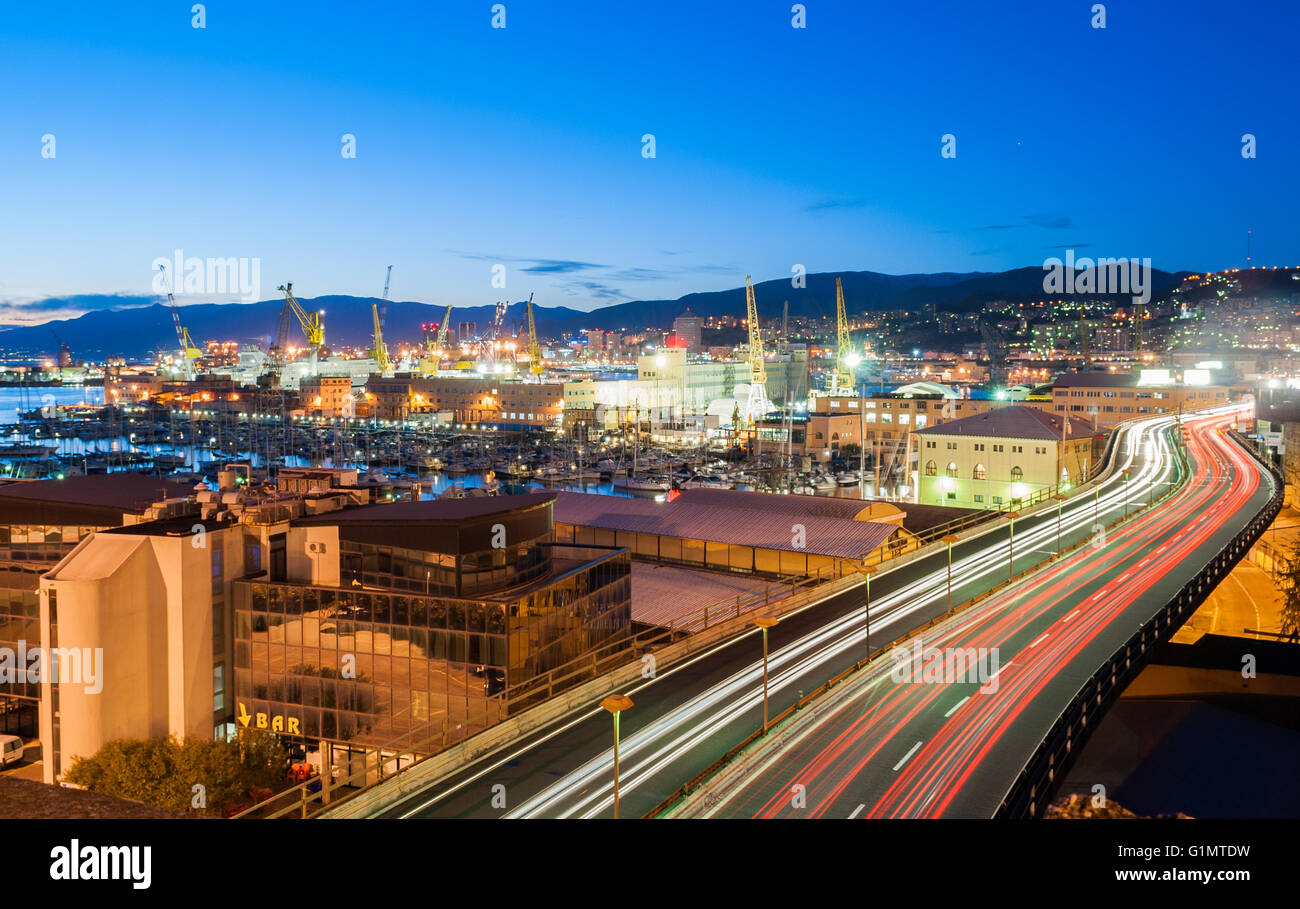 Il traffico in una strada di Genova durante il crepuscolo Foto Stock