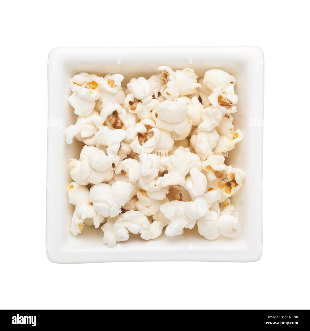 Plain popcorn in un recipiente quadrato isolato su sfondo bianco Foto Stock