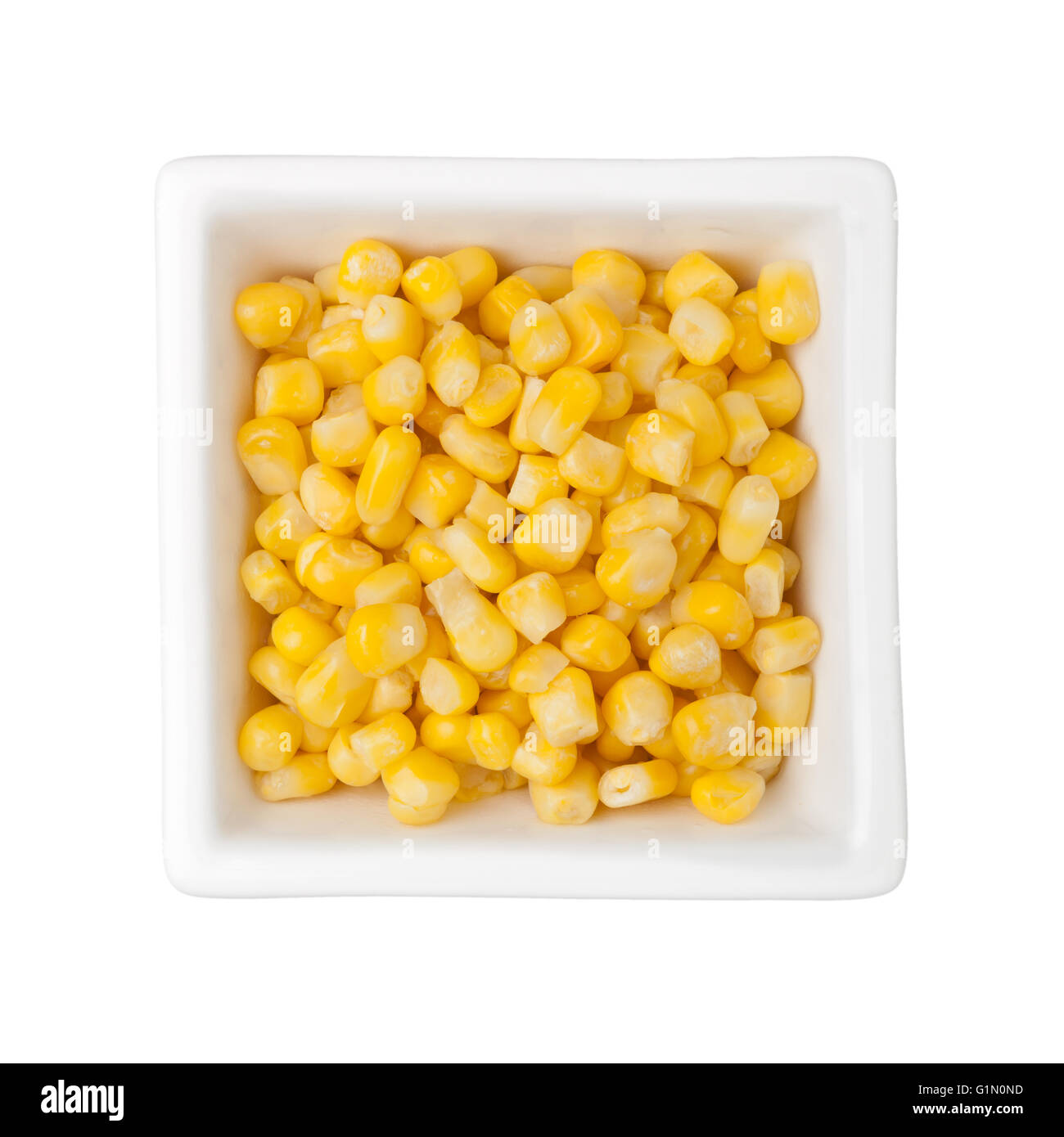 Chicchi di mais in un recipiente quadrato isolato su sfondo bianco Foto Stock