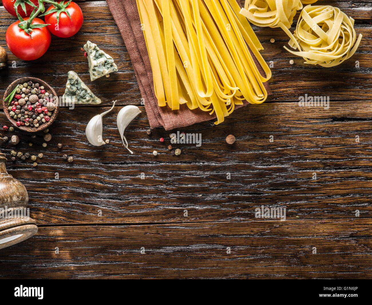 Ingredienti per la pasta. Cherry-pomodori, spaghetti formaggio blu sul tavolo di legno. Foto Stock