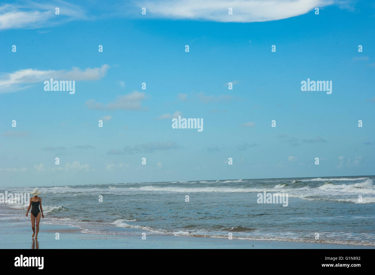 Lone donna spiaggia a piedi a Ormond Beach, FL Foto Stock