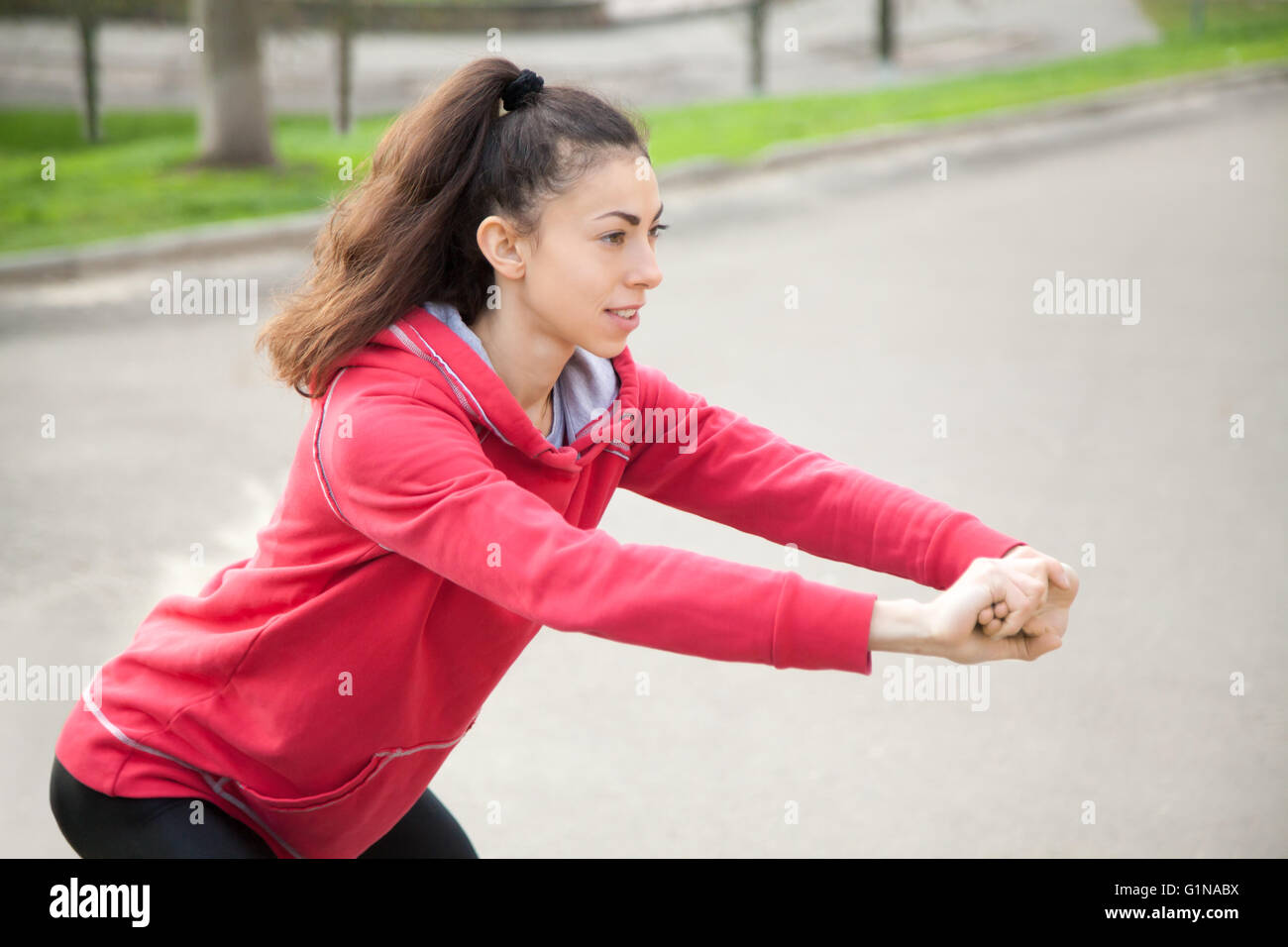 Ritratto di donna sportivo facendo esercizi di stretching in posizione di parcheggio prima del training. Atleta femminile la preparazione per il jogging all'aperto Foto Stock