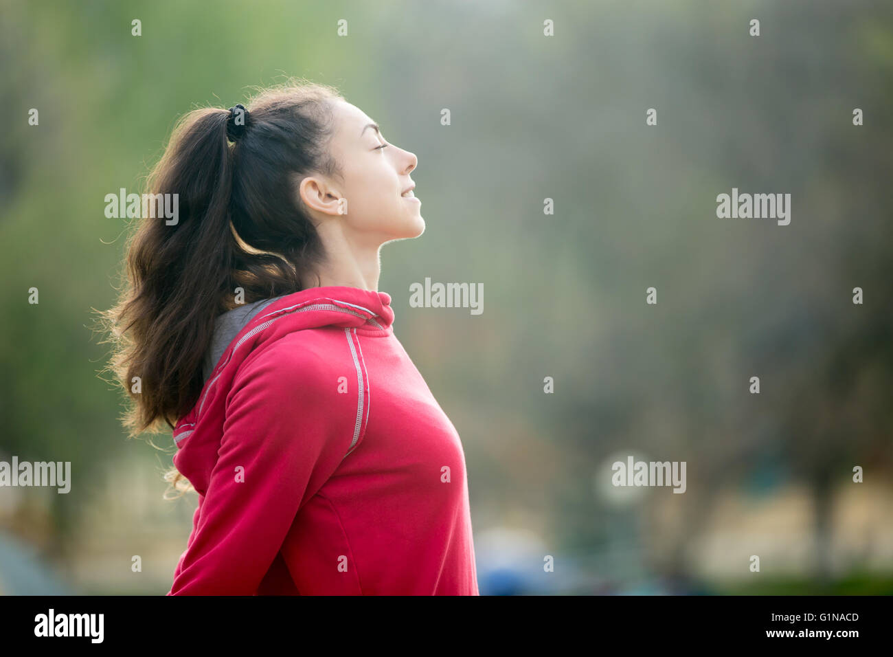 Ritratto di profilo di felice sportivo da donna relax nel parco. Modello femminile rilassante, respirando aria fresca all'aperto Foto Stock