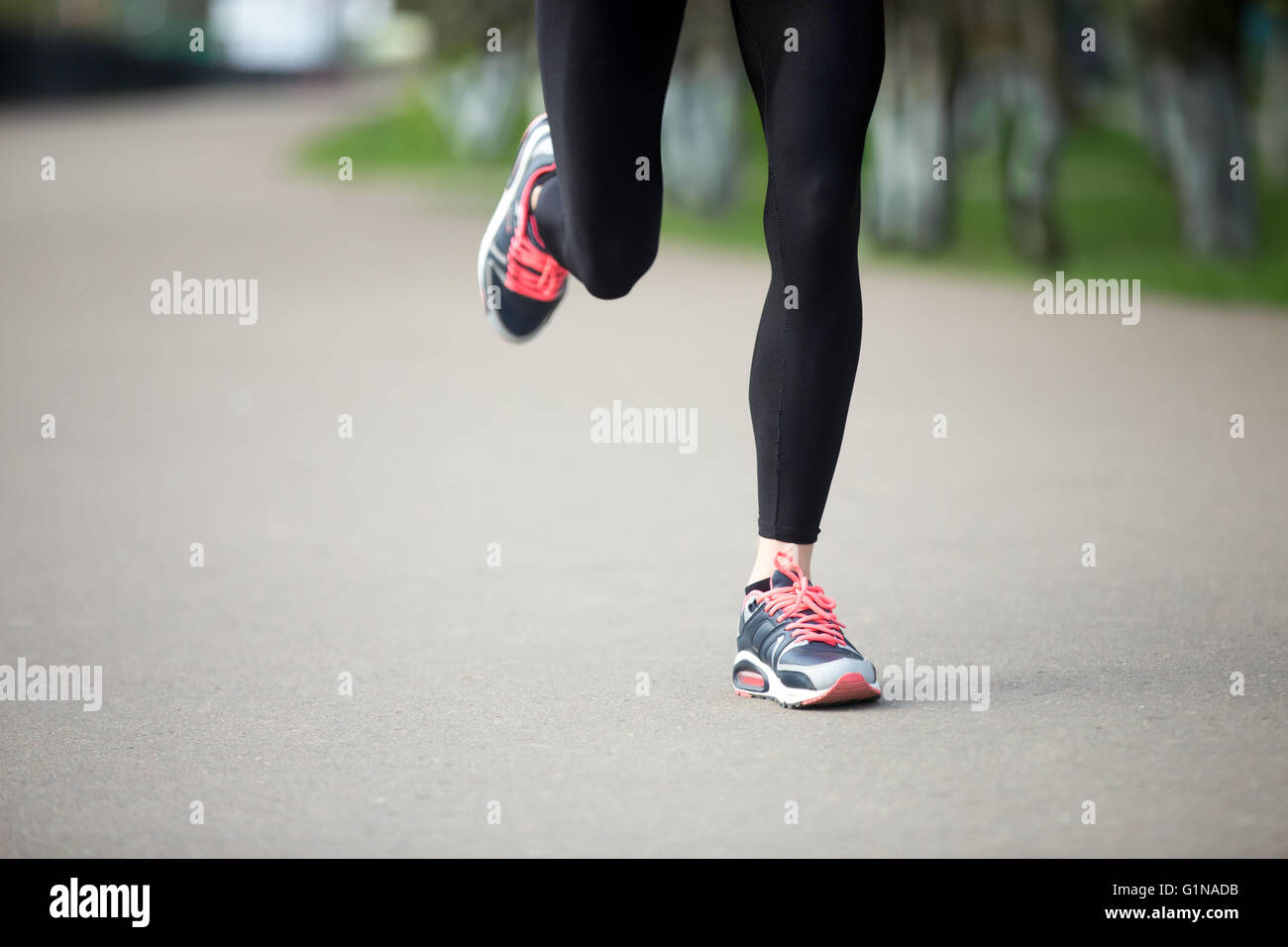 Le gambe del giovane femmina modello funzionante nel parco durante la pratica quotidiana. Donna Fitness in scarpe da jogging all'aperto nel parco Foto Stock