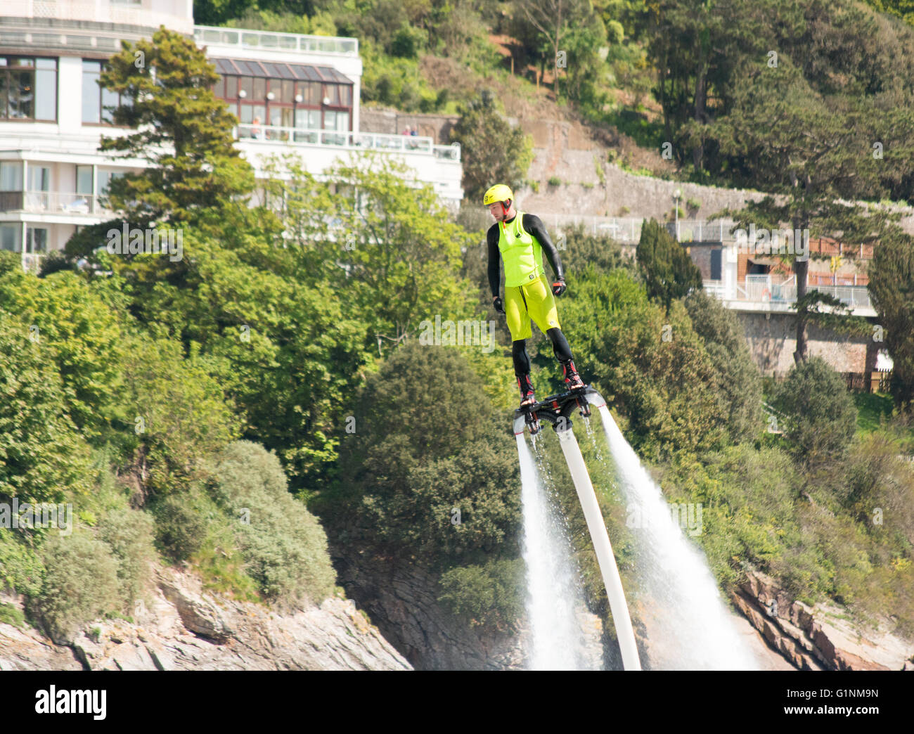 Un appassionato di flyboarding dimostra lui specialità con lo sport a Torquay, Devon, Regno Unito. Foto Stock