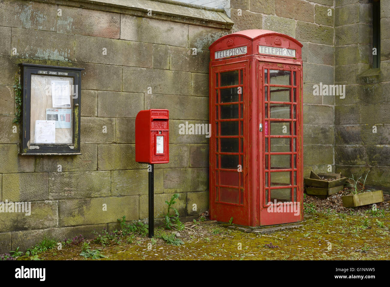 Un rosso casella postale e telefono rosso box nel centro del villaggio di Harthill nel Cheshire Regno Unito Foto Stock
