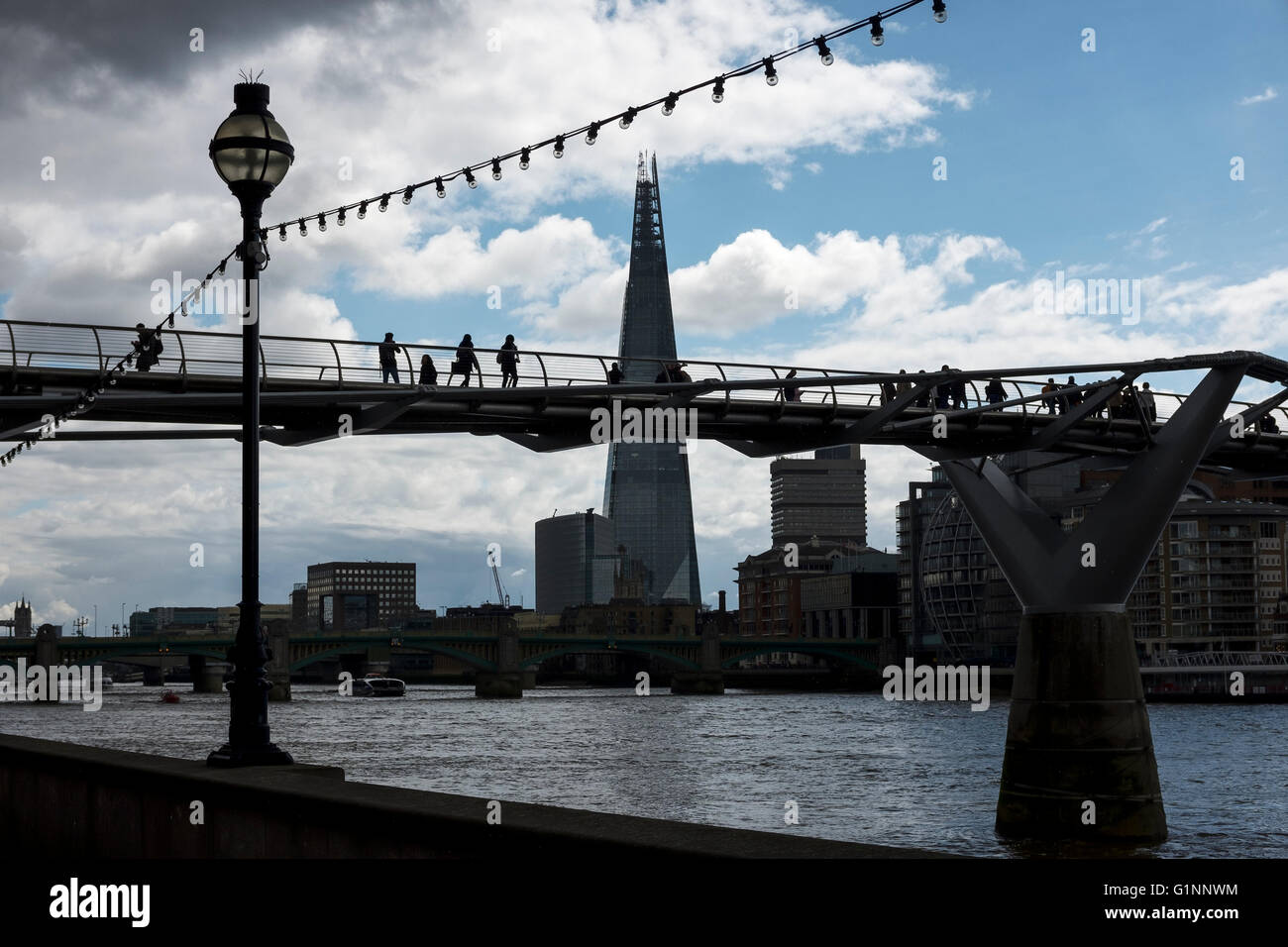 Silhouette di Shard e persone che attraversano il Millennium Bridge London REGNO UNITO Foto Stock
