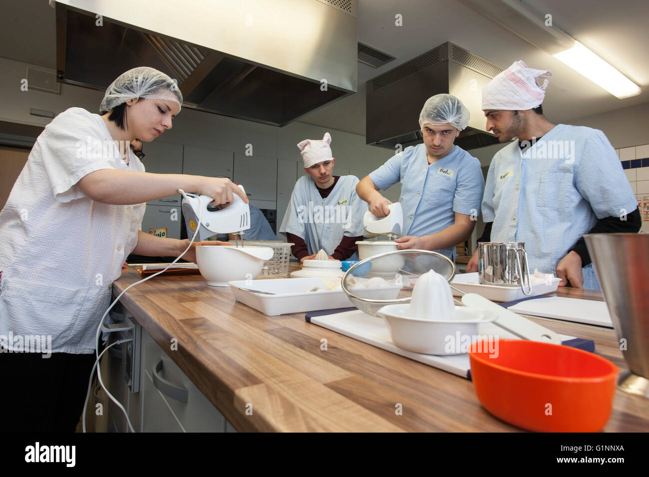 Scuola Internazionale di classe impara a cucinare e cuocere nella cucina di formazione. Foto Stock