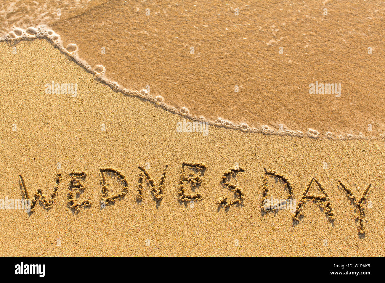 Mercoledì - scritta a mano su una luce dorata spiaggia di sabbia. Foto Stock