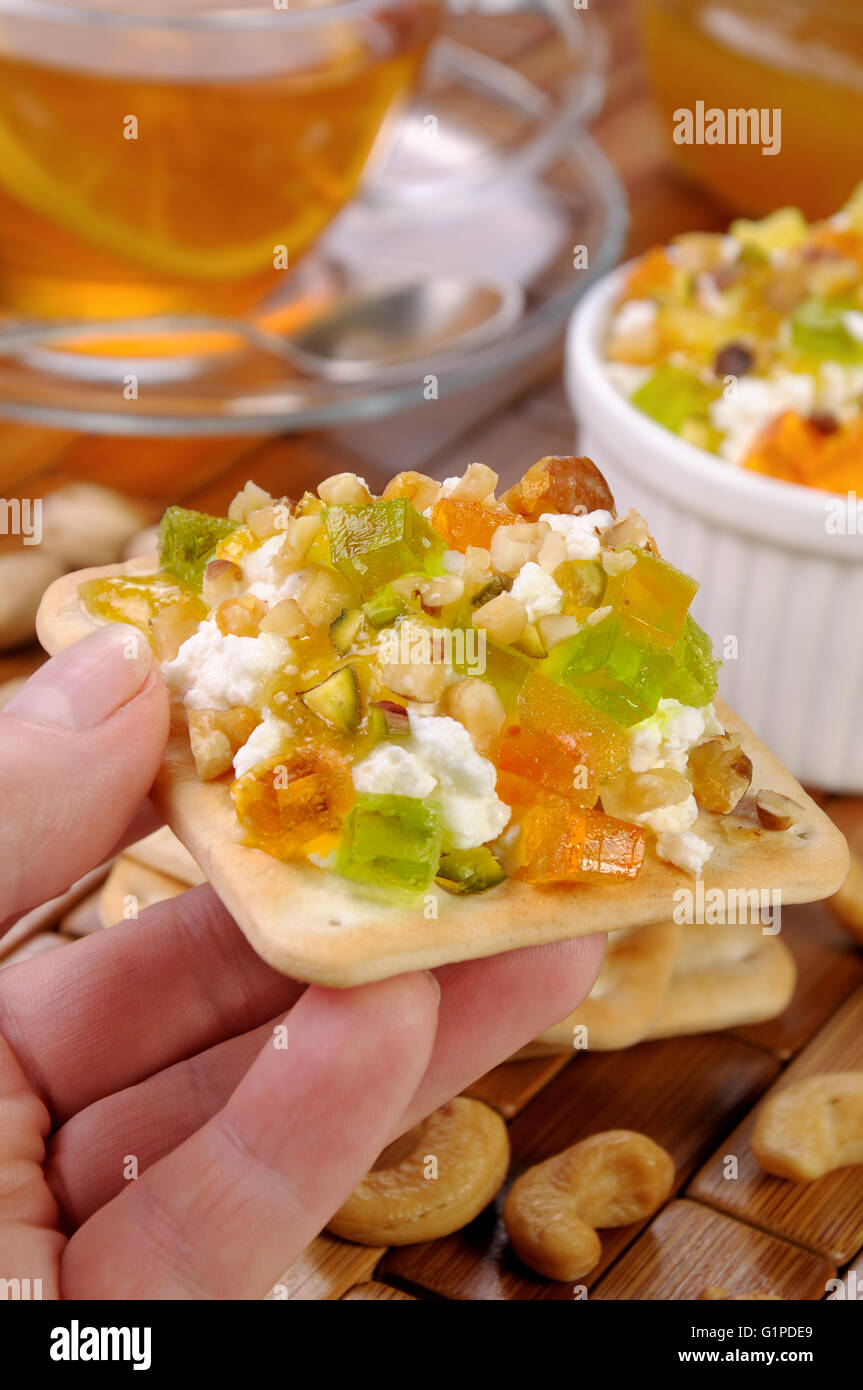 Porzione di formaggio con marmellate e confetture, dadi su un cracker Foto Stock