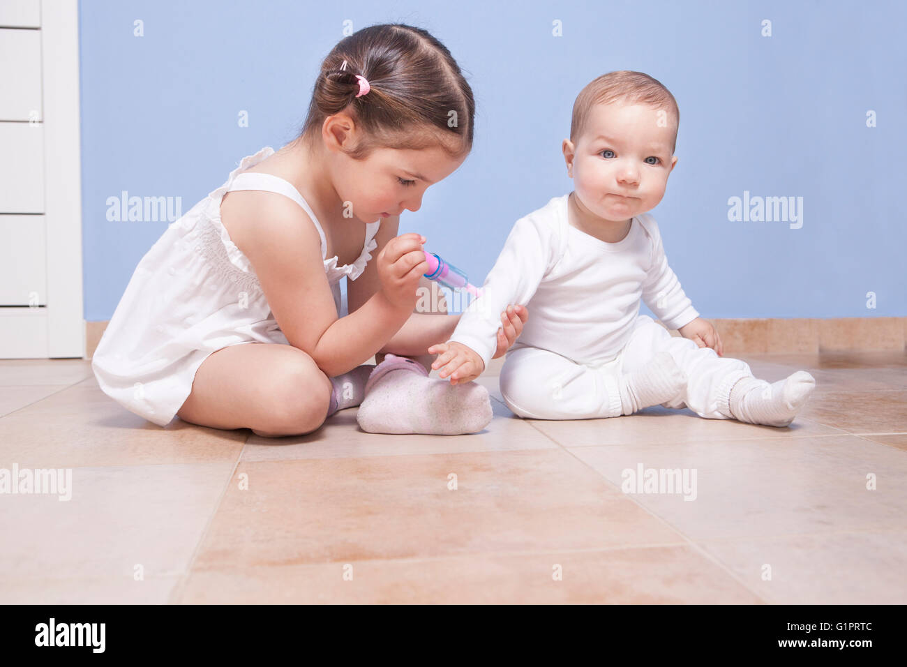 Baby fratello e sorella toddler riproduzione medico con una siringa Foto Stock