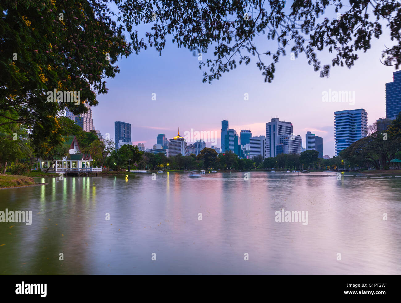Vista tramonto dell'orizzonte cittadino di Bangkok in pubblico Lumpini Park, Bangkok, Thailandia Foto Stock