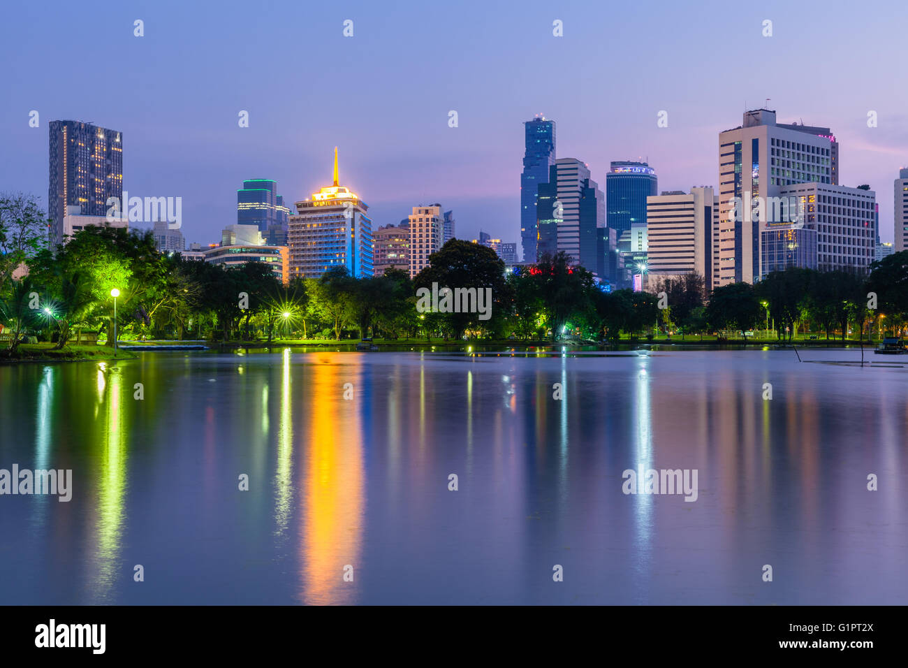 Crepuscolo vista dello skyline della citta' in pubblico Lumpini Park, Bangkok, Thailandia Foto Stock